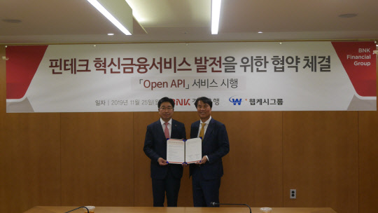 황윤철 BNK경남은행장(왼쪽)과 석창규 웹케시그룹 회장이 25일 BNK경남은행 본점에서 MOU 체결 후 기념촬영을 하고 있다.  웹케시 제공